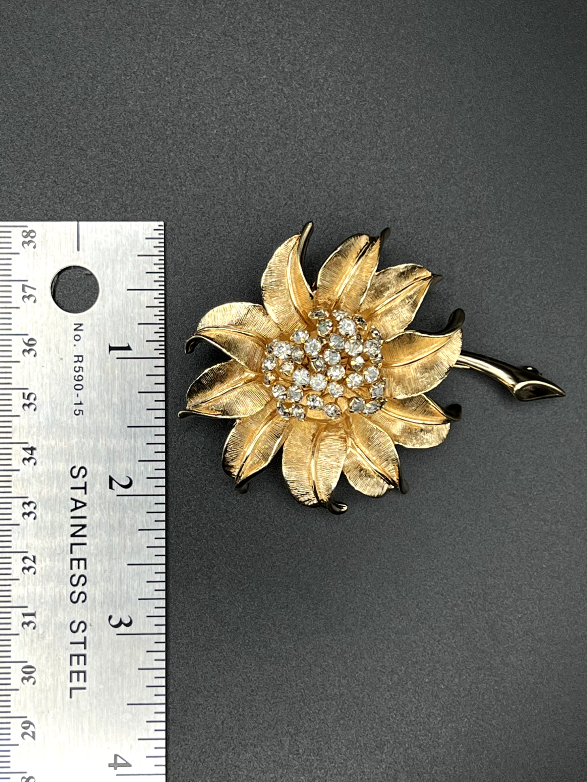 "Vintage gold-toned flower brooch pin back view showing clasp construction"