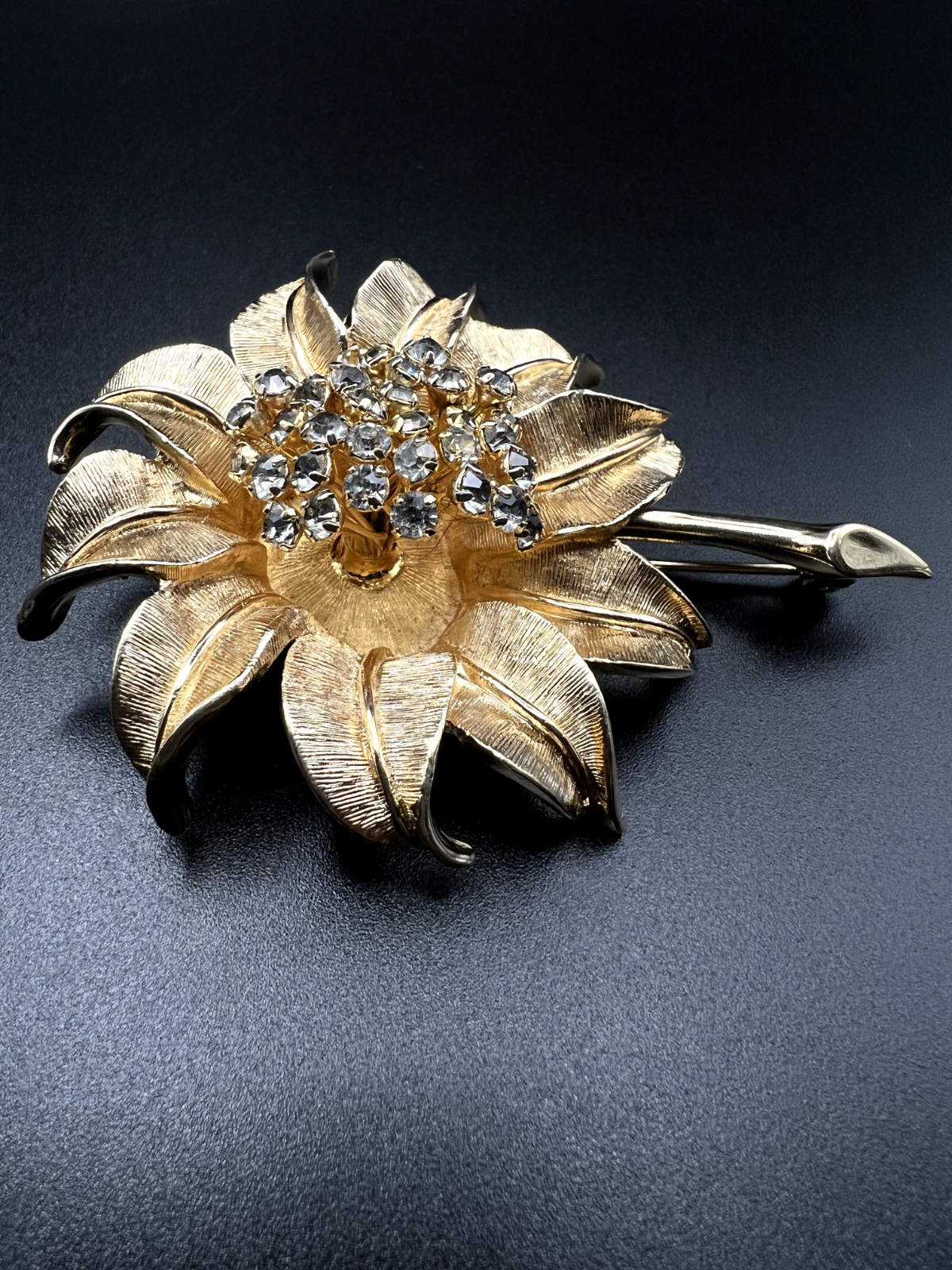 "Vintage gold-toned flower brooch pin with clear rhinestone accents front view"