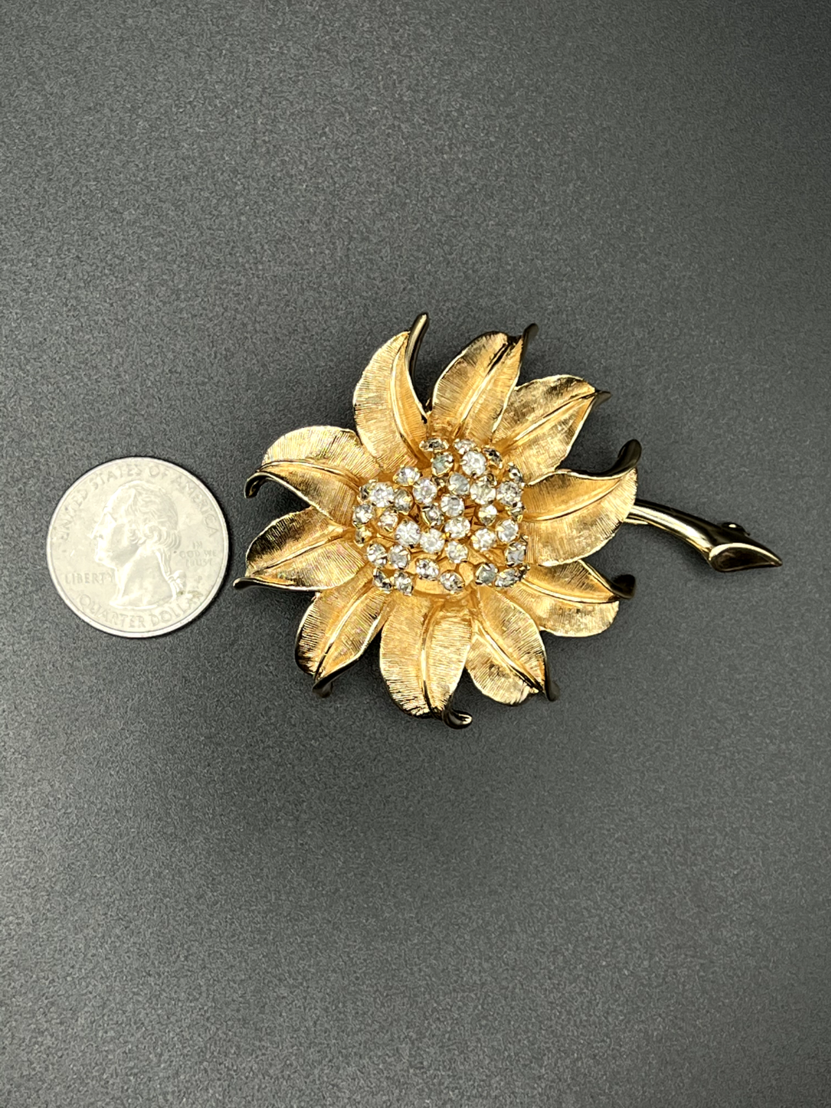 "Vintage gold-toned flower brooch pin side view showing rhinestone flower design"